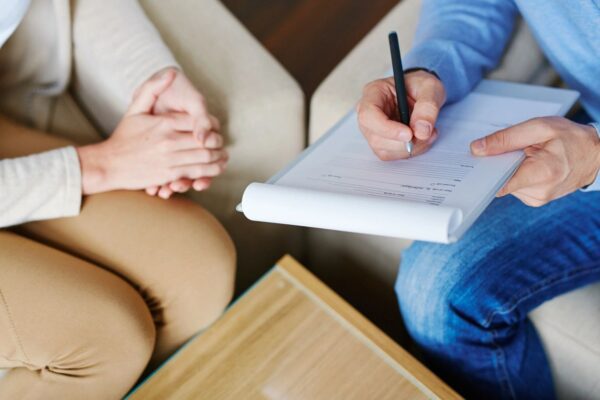 A Notepad in a Mans Hand With a Pen